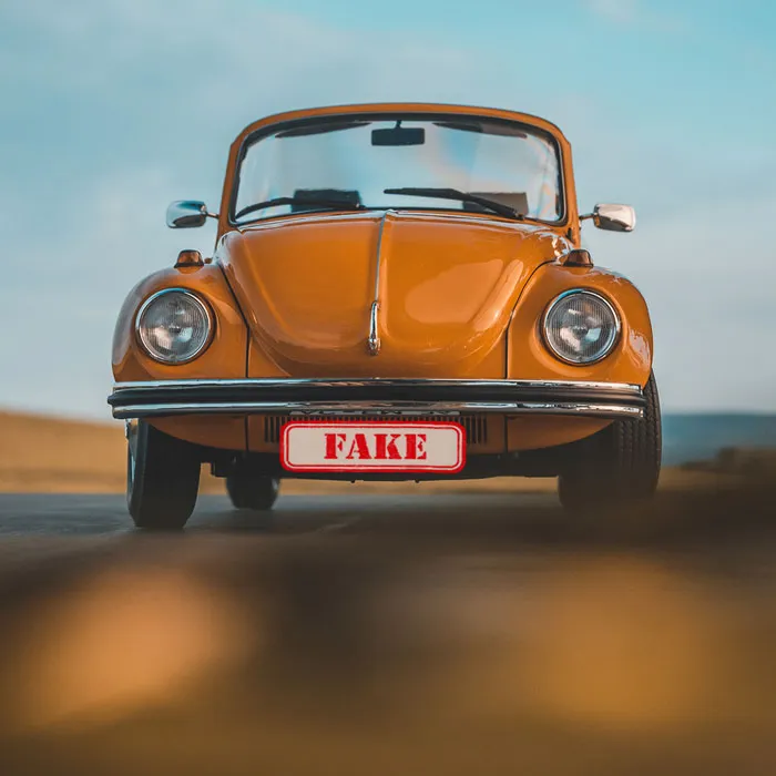 Das soll ein gefälschter Oldtimer sein? Auf dem Bild ist ein orangefarbener VW Käfer las Cabrio zu sehen. Auf dem Nummernschild steht "FAKE".