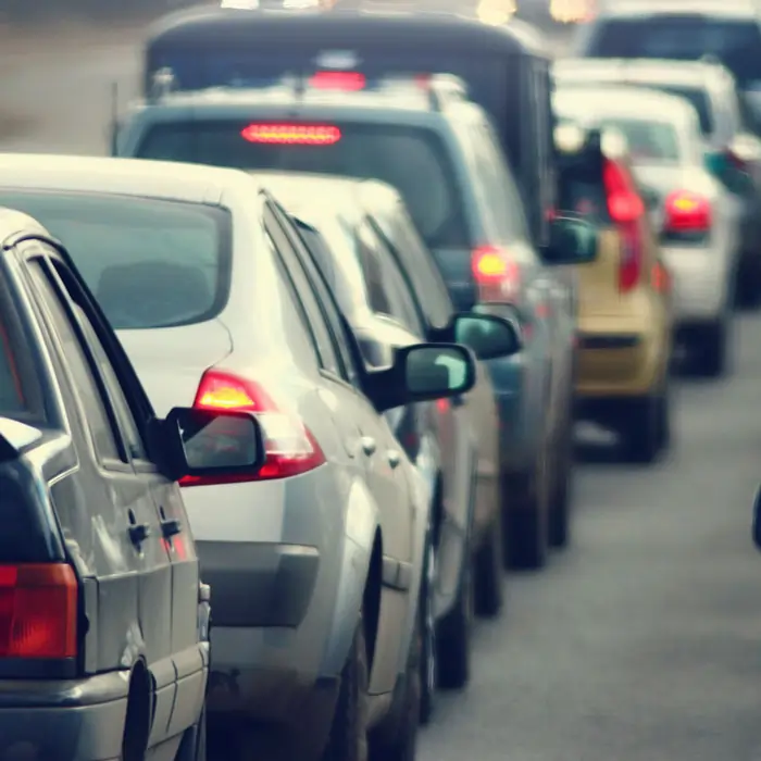 In Staus sind sehr viel Fahrzeuge dicht an dicht hintereinander gereiht und kommen nicht vorwärts. Rote Bremslichter zeigen an, dass die Fahrzeuge stehen.