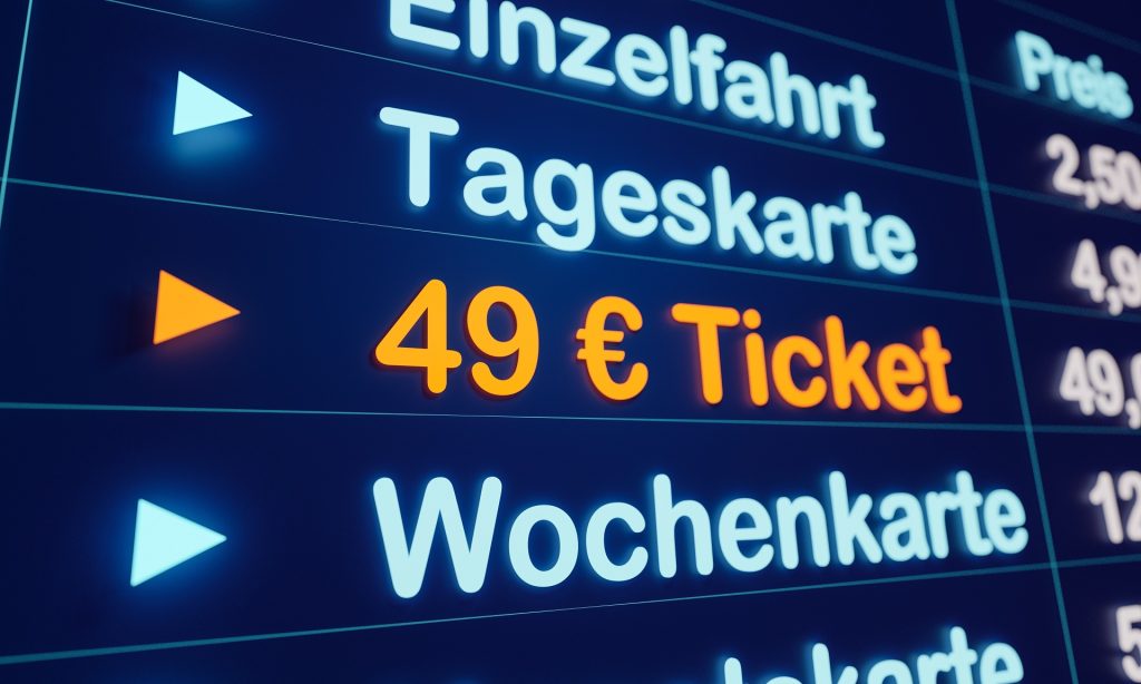 Eine digitale Preistafel zeigt die Preise für Einzelfahrt. Tageskarte, 49€ Ticket und Wochenkarte an. Die Schrift für das 49€ Ticket ist Orange hervorgehoben.